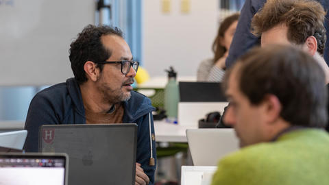 student in front of laptop speaking to another student